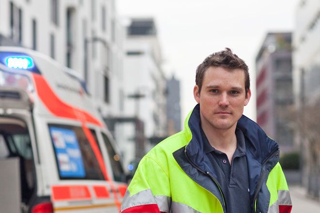 Foto: Ein junger Mann im Freiwilligendienst begleitet eine ältere Dame durch die Gänge einer stationären Einrichtung. Die Dame scheint sich über ihre Begleitung sichtlich zu freuen.